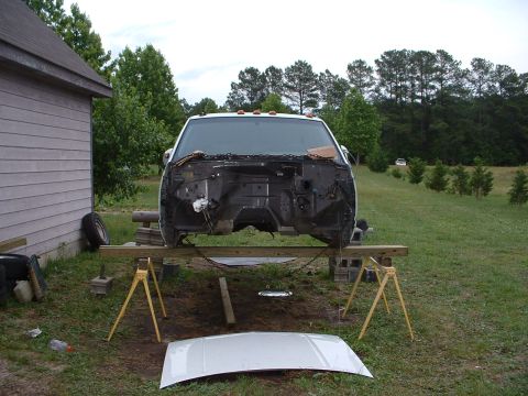 1994 GMC Suburban - The front end of a truck, possibly a 1995 model, is disassembled and supported by sawhorses outdoors.