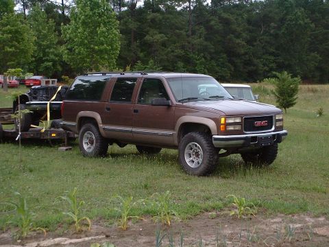 1994 GMC Suburban - This brown 1995 GMC Suburban is seen outdoors towing a trailer.