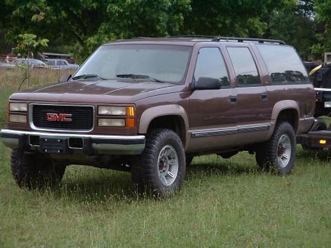 1994 GMC Suburban - This GMC Suburban is parked in a grassy area with trees in the background.