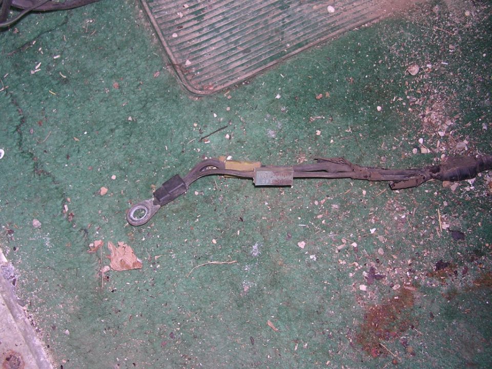 Automotive wiring harness with a ring terminal on a green carpeted surface