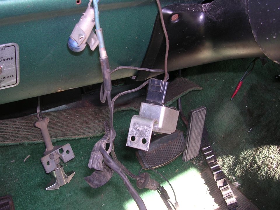 Under dash wiring with pedals and a relay. Some text labels visible on the dash panel