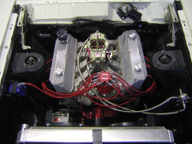 V8 engine bay showing aftermarket valve covers, carburetor, and MSD ignition
