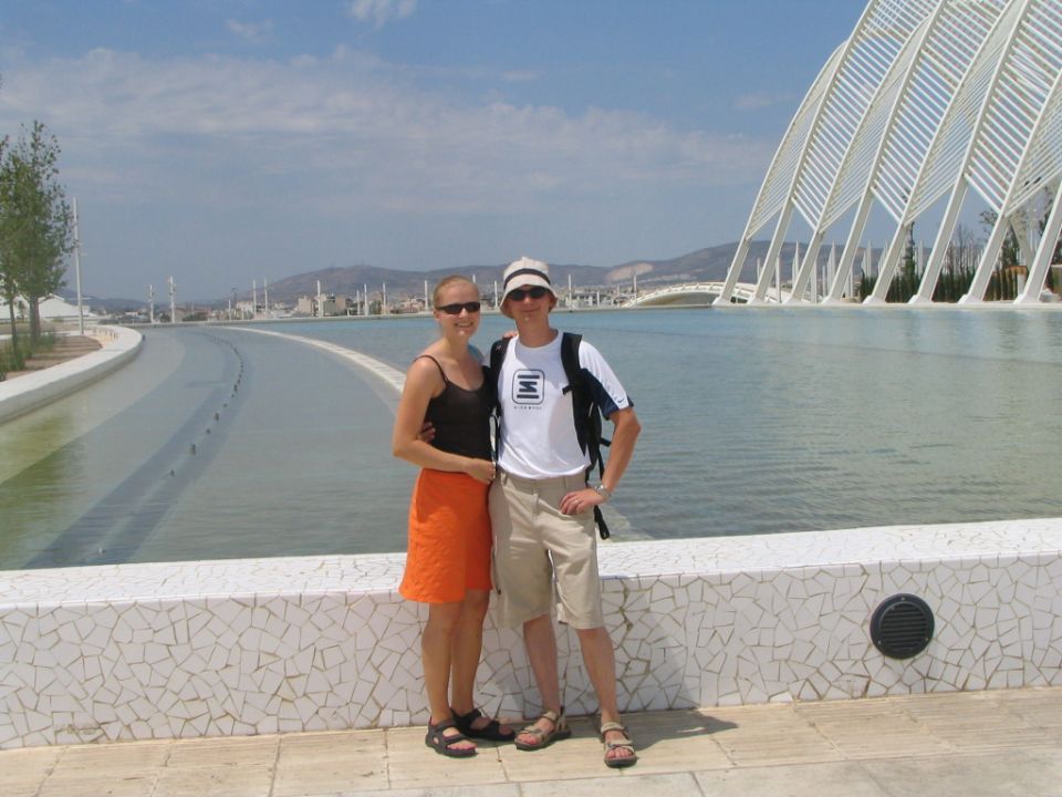Couple posing by water feature with modern architecture