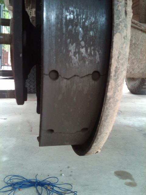 1982 Ford Bronco - Close-up view of cracked brake shoes within a brake drum, indicating a need for replacement.