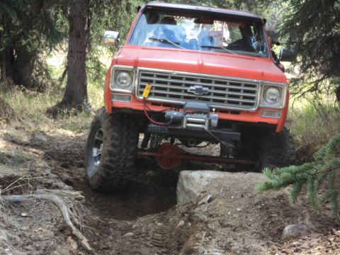 1990 Chevrolet Suburban - This heavily modified truck navigates a challenging off-road course with its front end angled towards the viewer.
