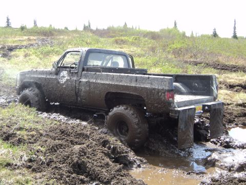 1990 Chevrolet Suburban - This pickup truck is deeply stuck in thick mud, with its front end almost completely submerged.