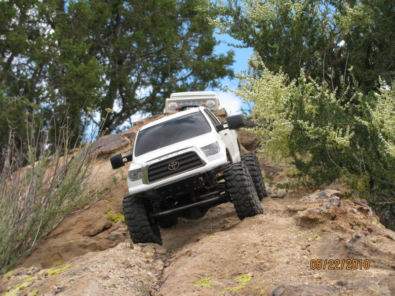 White remote control Toyota Tundra truck with large tires climbing rocks