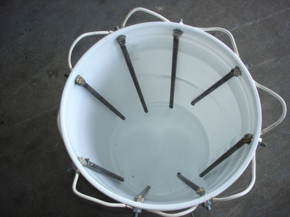 Bucket with water, rebar electrodes, and wires for electrolysis rust removal