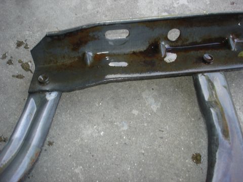 1979 Ford F-250 - Close-up of a metal frame part with pipes, exhibiting signs of rust and liquid residue.