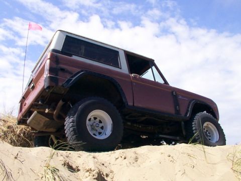1980 Ford Bronco - This 1980 Ford Bronco navigates a sandy incline under a cloudy sky.