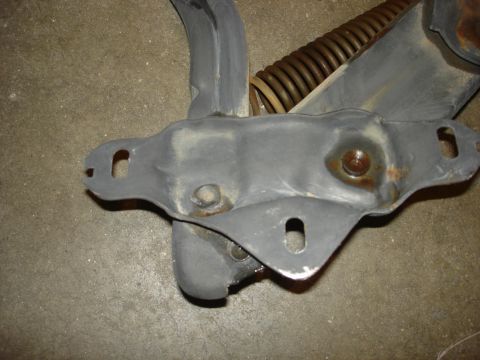 1979 Ford F-250 - Close-up of a vehicle's hood hinge assembly, showing mechanical components and signs of wear.