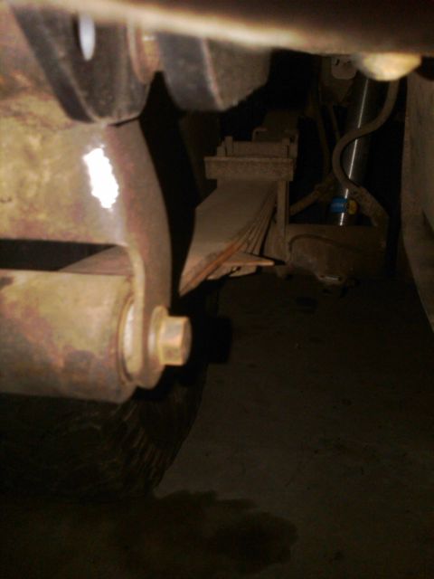 1982 Ford Bronco - Close-up view of the leaf spring suspension system, a blue shock absorber.