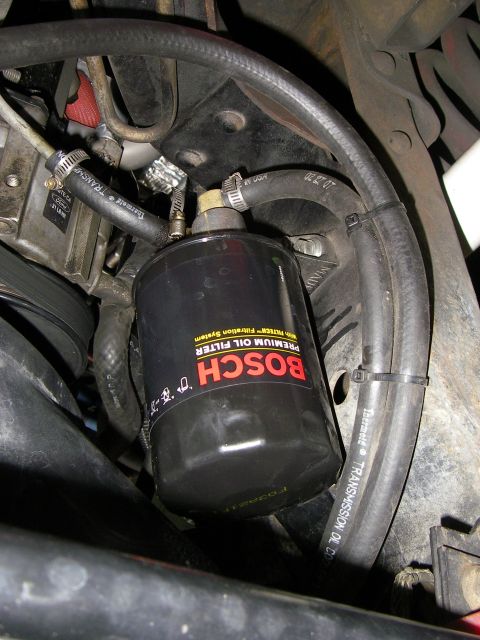 1990 Ford Bronco - Close-up view of a Bosch premium oil filter installed in an engine bay, surrounded by hoses and other mechanical parts.