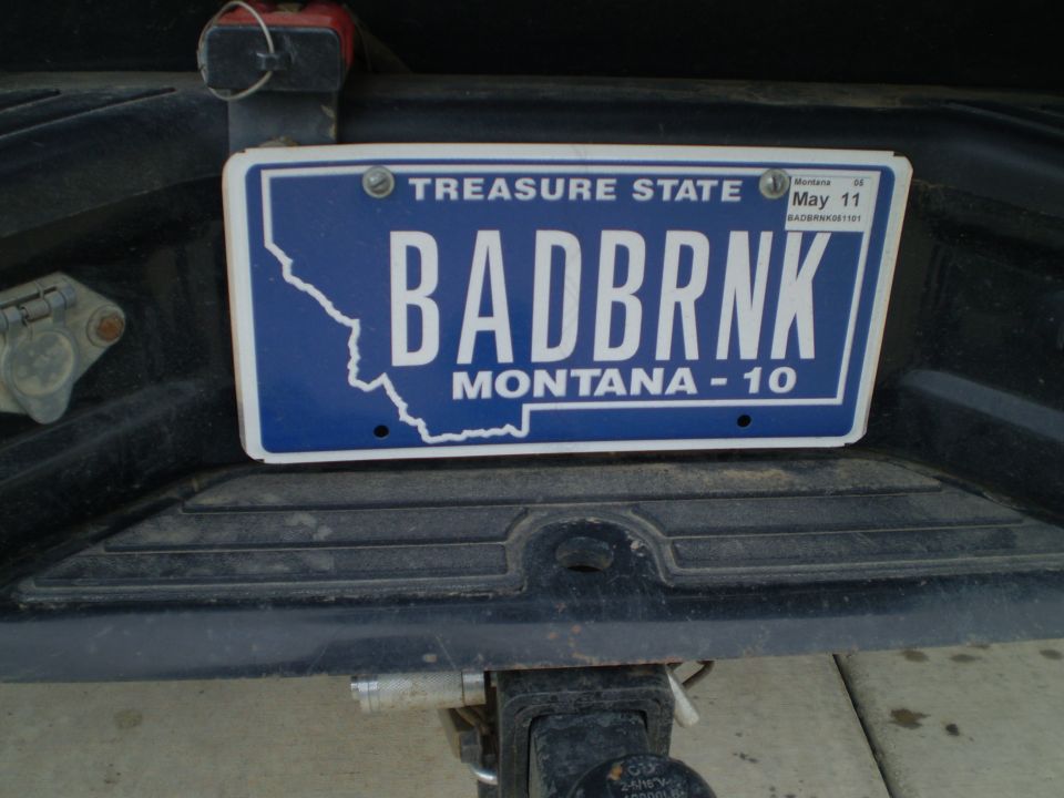 License plate on a dark-colored vehicle's rear bumper