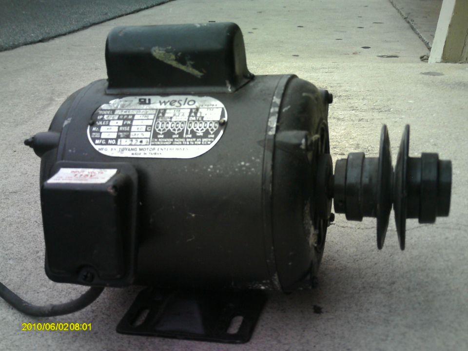 Black electric motor with a Weslo label and a two-pulley system attached to the shaft