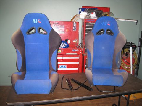 1969 Ford F-250 - Two blue racing seats with AK logos are displayed on a workbench in front of tool chests.