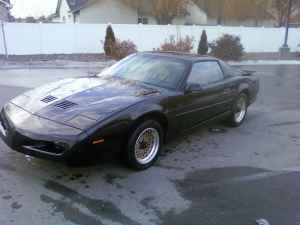 1991 Pontiac Firebird - Black 1991 Pontiac Firebird coupe with aftermarket wheels parked outside.