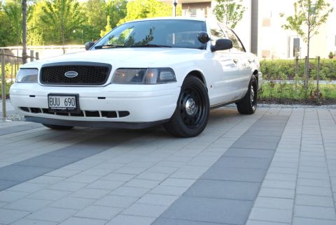 1998 Ford Crown Victoria - A white 1998 Ford Crown Victoria is shown from a three-quarter front angle on a paved surface.
