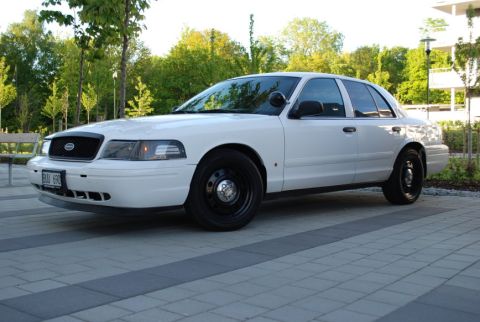 1998 Ford Crown Victoria - White 1998 Ford Crown Victoria police car with black steel wheels parked outdoors.