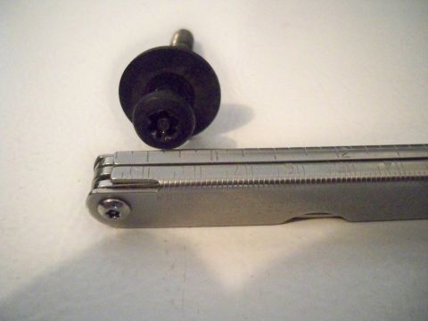 1994 Ford Bronco - A close-up shows a single screw and a multi-tool with measurement markings.