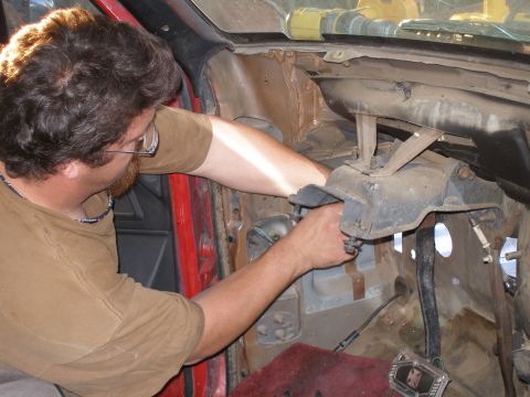 1969 Ford F-250 - Man working on the dashboard and steering column area of a vehicle interior.