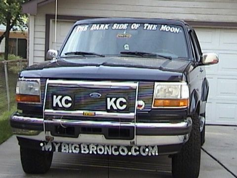 1995 Ford Bronco - Frontal view of a dark blue 1995 Ford Bronco, adorned with custom decals on the windshield and bumper.