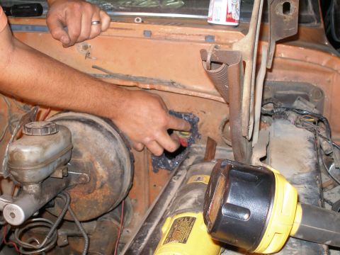 1969 Ford F-250 - Firewall repair in progress, showing sealant application and tools.