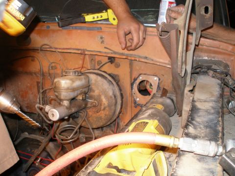 1969 Ford F-250 - Close-up view of the firewall area of a vehicle undergoing mechanical work, showing the brake system components.