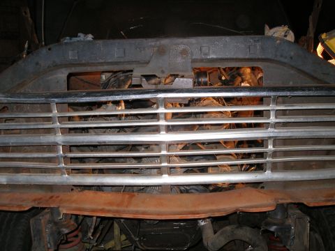 1969 Ford F-250 - The front grille of a 1967 Ford F-250 truck is visible, with the engine compartment behind it.