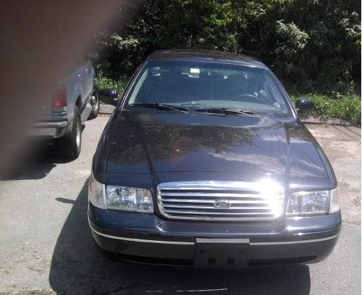 Front view of a dark 2003 Ford Crown Victoria with a chrome grille