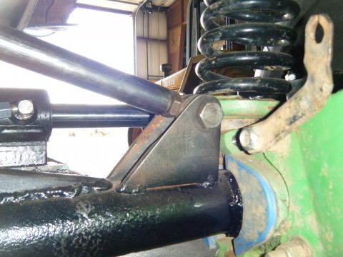 1978 Ford Bronco - Detail of a vehicle's suspension system, showing a coil spring and mounting hardware.