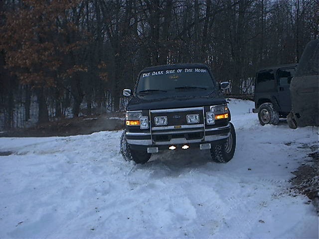 1995 Ford Bronco front view in snow with another SUV behind it