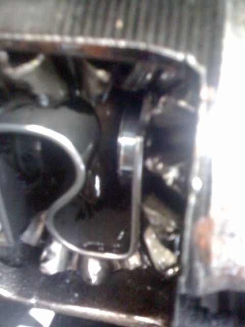 1995 Ford Bronco - Close-up view of engine components, including the radiator and fan, in a dark and oily environment.