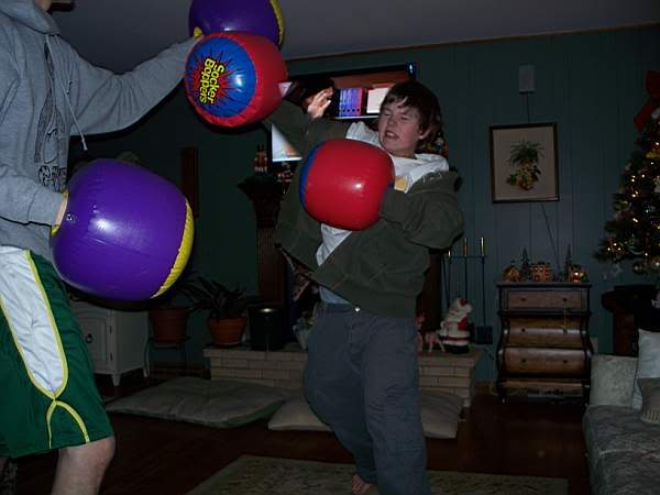 People playing with inflatable boxing gloves indoors