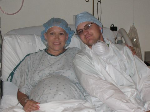 2001 Pontiac Trans Am - A pregnant woman and a man in a hospital room, both wearing surgical caps and gowns.