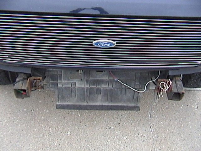 1995 Ford Bronco front grille with horizontal bars and Ford logo, showing bumper area with wiring