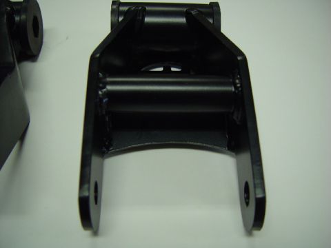 1993 Ford Bronco - A close-up view of a black metal suspension component, possibly a shackle or bracket, against a white background.