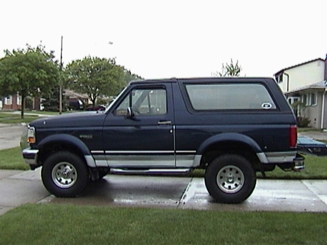 1995 Ford Bronco parked on a wet driveway, side view