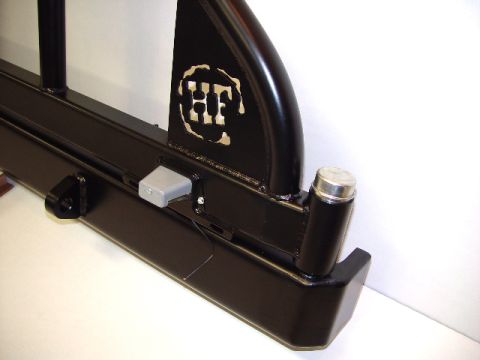 1993 Ford Bronco - Close-up of a black steel aftermarket rear bumper a cut-out HF logo and a gray latch.
