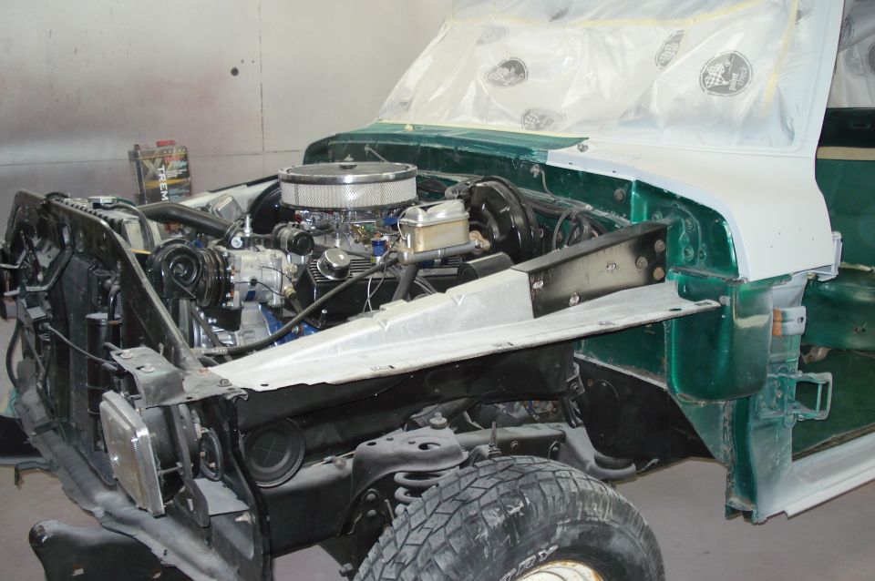 1979 Ford F-150 engine bay with engine removed for restoration, green body panels visible