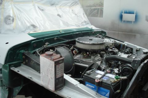 1979 Ford F-150 - The engine compartment of a truck is shown, with various parts and a container of fluid visible.
