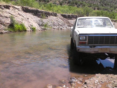 1981 Ford F-150 - White 1979 Ford F-Series pickup truck crossing a shallow river on a sunny day.