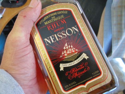 1990 Ford Bronco - A hand holds a bottle of Neisson Rhum Agricole, a sailing ship and "Réserve Spéciale" text.