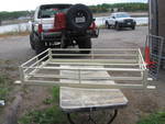 1991 Ford Bronco - A white SUV is viewed from the rear, equipped with a spare tire and a cargo rack. A second white vehicle is in the background.