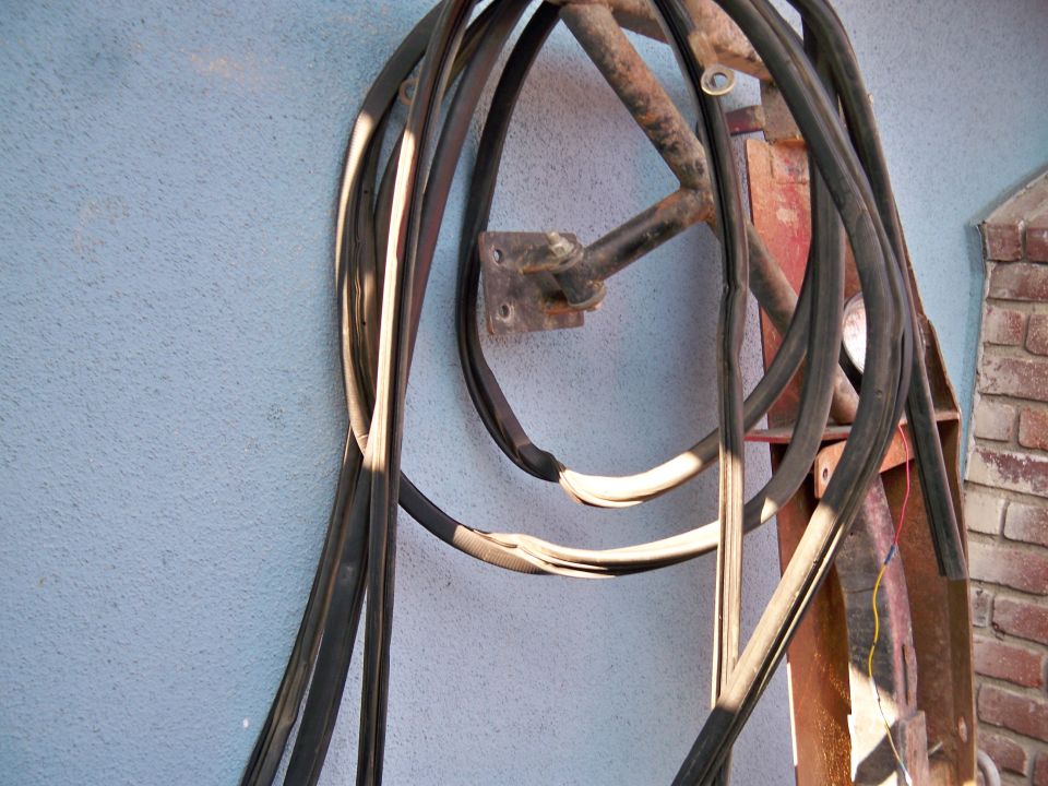 Rubber seals hanging on a blue wall with a rusty metal bracket