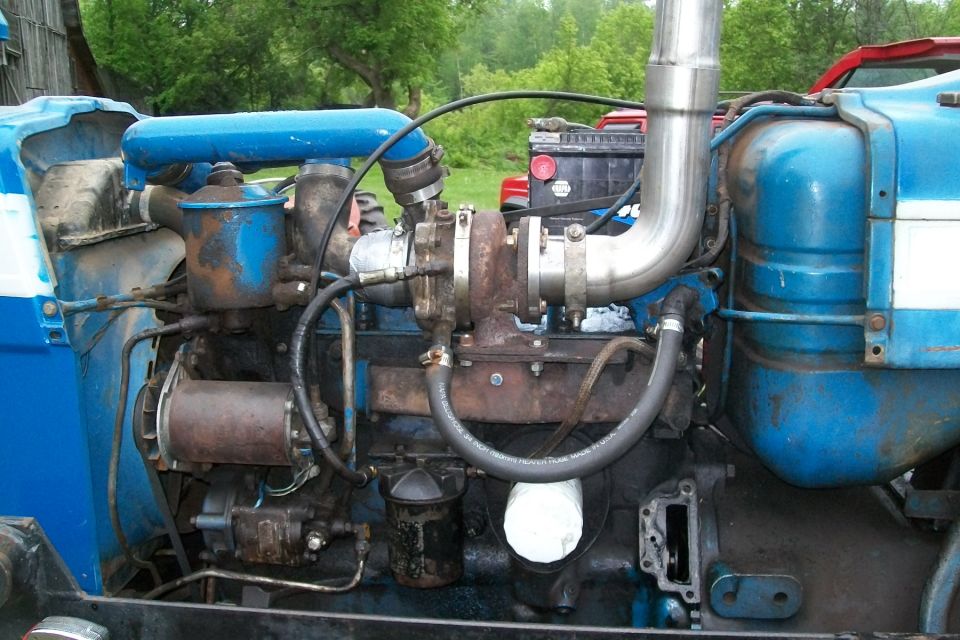 Blue tractor engine bay with turbocharger, injection pump and stainless exhaust
