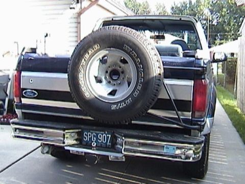 1995 Ford Bronco - This Ford pickup truck features a spare tire mounted on the rear tailgate, obscuring part of the license plate.