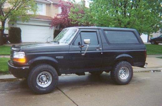 Black full-size Ford Bronco two-door SUV parked at a suburban curb