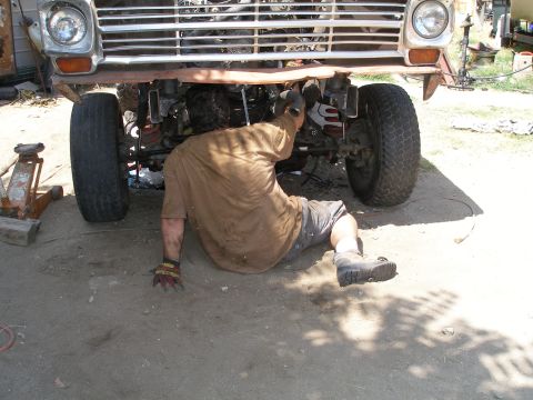 1969 Ford F-250 - Mechanic works on the front suspension of a truck, possibly a 1967 Ford F-250.