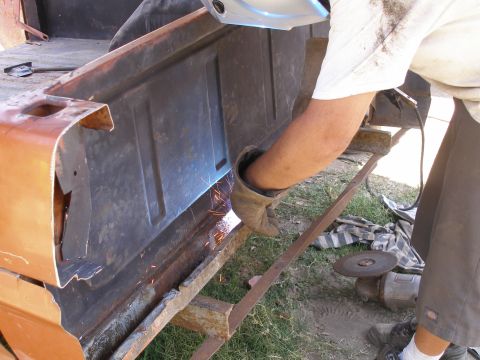 1969 Ford F-250 - Welding repairs being done on a truck bed panel, with sparks flying.